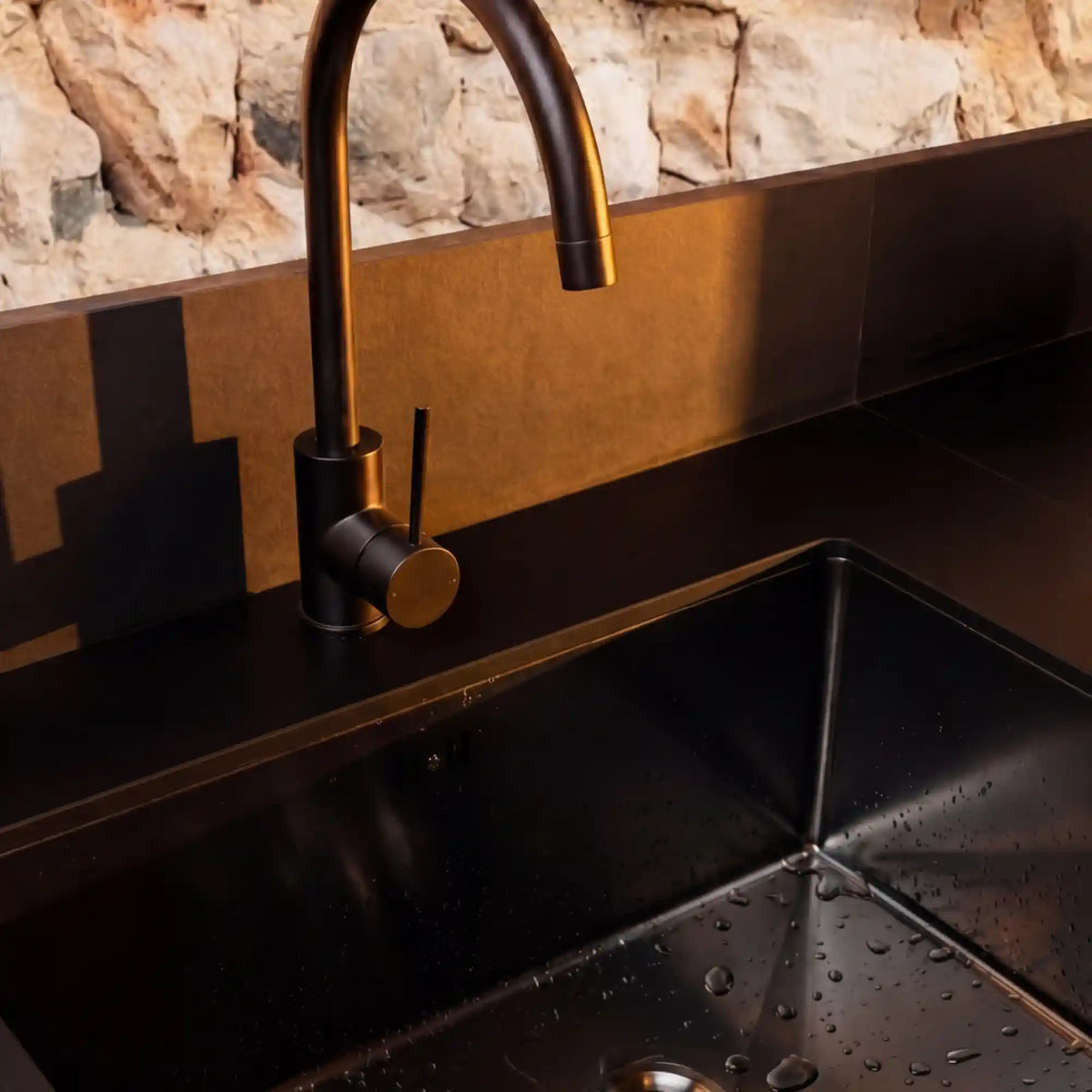 Schwarzer Wasserhahn an einem Spülbecken der PILOTIS-Außenküche montiert
::visuel:noir