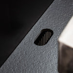 Detail der integrierten Kabeldurchführung in der schwarzen Keramik-Arbeitsplatte Pilotis.\n::visuel:noir