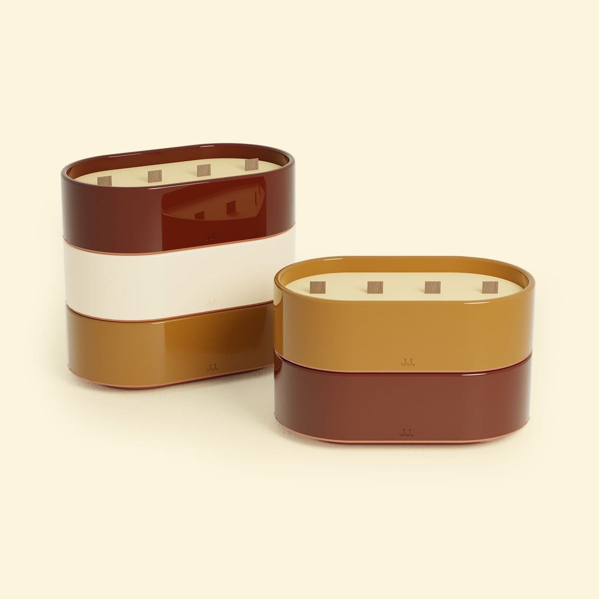 Bougies Totem L Rouge oxyde – Citronnelle & Géranium et Brun terre de sienne – Citronnelle & Fleur d’oranger, deux grandes bougies ovales à triple mèche en bois, posées sur un fond beige clair.