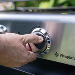 Gros plan sur une main ajustant le bouton de réglage de la plancha Vivaplancha en inox pour contrôler la température.