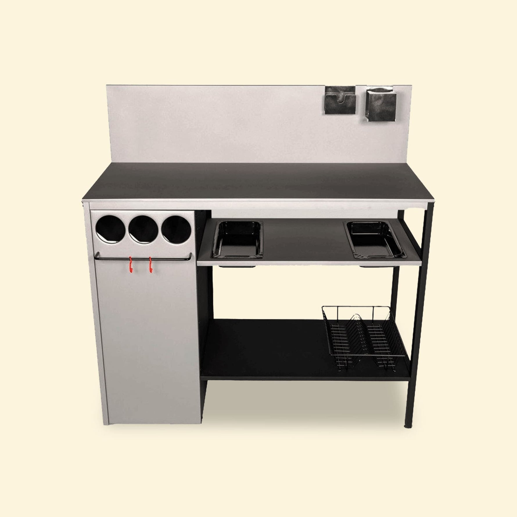 Module de cuisine extérieure complet avec crédence, rangements cylindriques, barre porte-ustensiles, bacs intégrés et panier de rangement inférieur, présenté de face sur fond uni clair.
