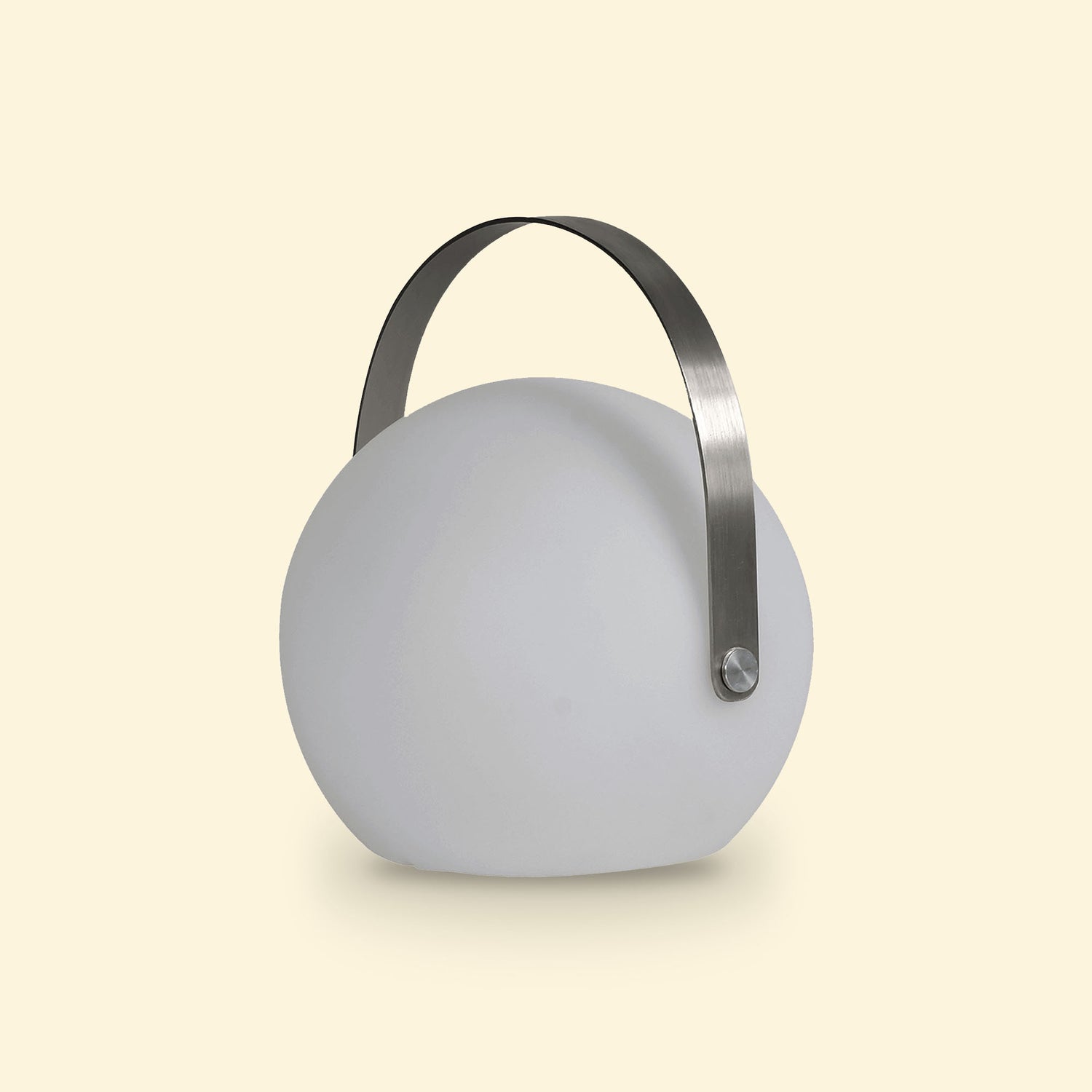 Lampe ronde d’extérieur solaire éteinte, avec anse métallique arquée, posée sur un fond beige clair.